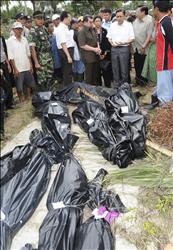 نائب الرئيس الأندونيسي بوديونو (أعلى اليمين) يعاين جثث ضحايا التسونامي في جزر منتاواي أمس