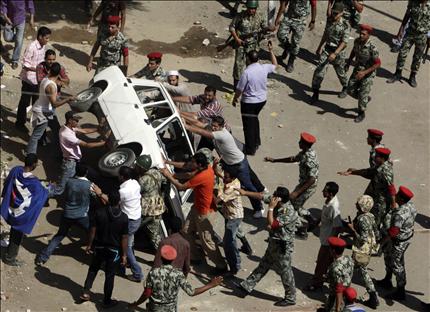 مصريون يهاجمون سيارة للشرطة في السويس أمس (رويترز) 