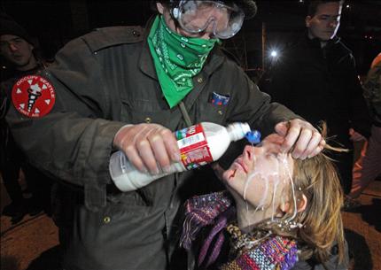 متظاهرة أميركية تتلقى علاجاً سريعاً بعد تعرضها لرذاذ الفلفل من عناصر أمن في سياتل فجر أمس (أ ب) 
