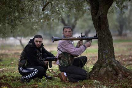 عنصران من «الجيش السوري الحرّ» يتوليان مهام الحراسة في بلدة سرمين، شمالي سوريا، أمس. (أ ب ) 