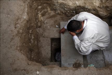 أحد أقارب عبدة علي عبد الحسين يبكي على قبرها في قرية جدحفص أمس (رويترز) 