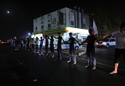 بحرينيون معارضون يشكلون سلسلة بشرية خلال تظاهرة للمطالبة بالإفراج عن المعتقلين في قرية سترة الاثنين الماضي (أ ب) 
