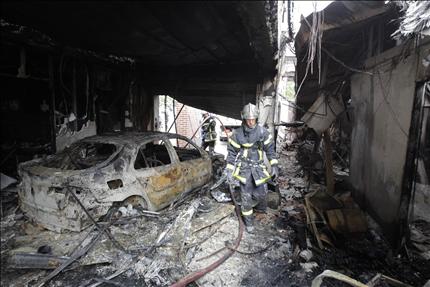 عنصران من الدفاع المدني الفرنسي يتفقدان آثار حريق في اميان في شمال البلاد امس (رويترز) 