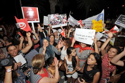 تونسيات يحملن لافتات كُتب عليها «لا تلمس حقوقي» خلال تظاهرة في العاصمة تونس فجر أمس (أ ف ب) 