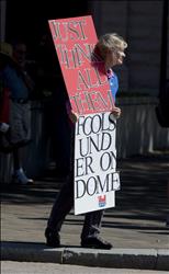 أميركية تحمل لافتة كتب عليها «أعتقد أنهم كلهم حمقى تحت سقف واحد» خلال المشاركة في تظاهرة ضد الإغلاق الحكومي في واشنطن أمس (أ ب) 