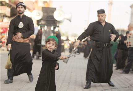 طفل عراقي يشارك في إحياء ذكرى عاشوراء في الكاظمية شمال بغداد أمس (ا ف ب) 