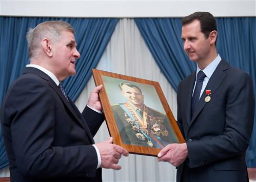 الاسد يتسلم هدية من عضو في الوفد الروسي في دمشق امس (ا ف ب)