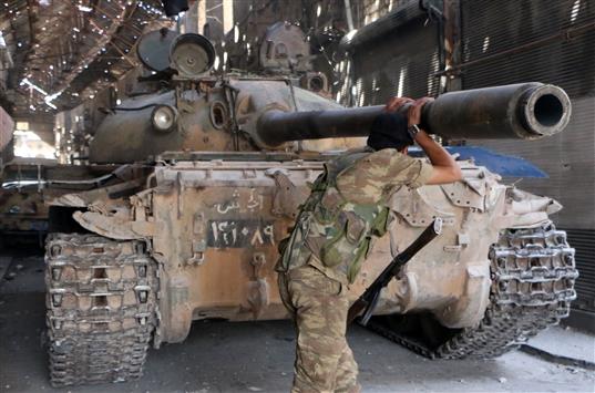 مسلح يتكئ على فوهة مدفع دبابة في حلب امس (ا ف ب)