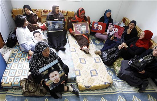 أمهات "شهداء الثورة" يرفعن صور أبنائهن خلال اليوم الخامس لإضرابهن عن الطعام احتجاجاً على قرار قضائي صدر في 12 نيسان الحالي ويقضي بتخفيف الحكم عن مسؤولين سابقين متهمين في قضايا القتل، في تونس أمس (رويترز)