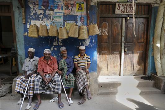 كينيون يجلسون أمام محل لبيع التذكارات في بلدة لامو بعد هروب السياح منها أمس (أ ب أ)