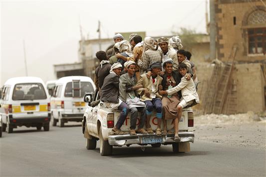 يمنيون على ظهر عربة نقل قرب صنعاء، أمس (رويترز)
