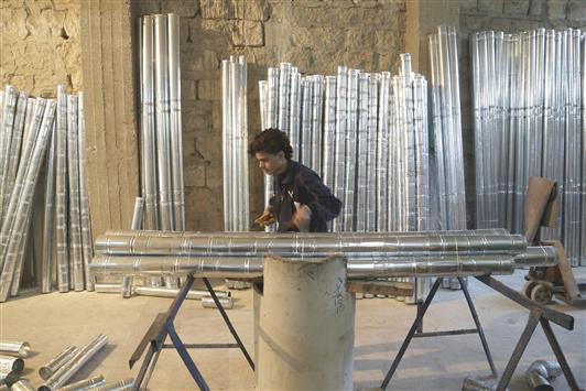شاب يعمل في مصنع لتصنيع المدافئ في ادلب (رويترز)