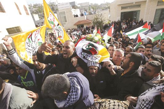 فلسطينيون يشيّعون جثمان الشهيد طرايرة في بلدة بني نعيم القريبة من الخليل في الضفة الغربية المحتلة أمس (رويترز)