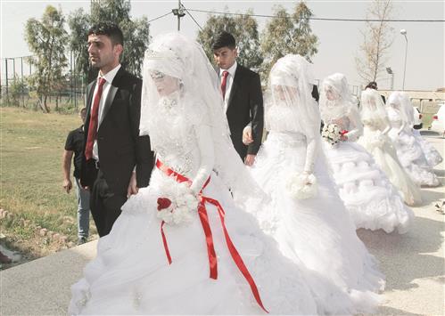 تركمان عراقيون، من النازحين من نينوى، خلال مراسم زواج جماعي في كركوك امس (رويترز)