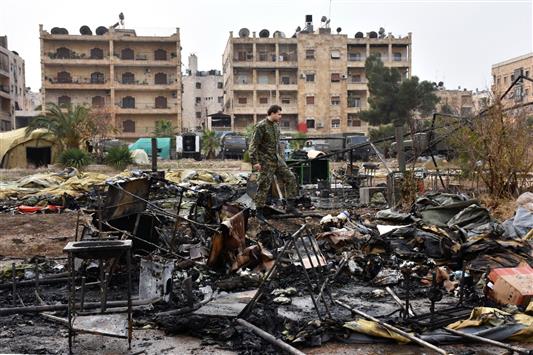 جندي روسي يتفقد الدمار اللاحق بالمستشفى الميداني الذي استهدفه المسلحون في حي الفرقان غرب حلب أمس (أ ف ب)