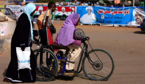 سودانيات يمررن بالقرب من ملصقات انتخابية في إقليم دارفور