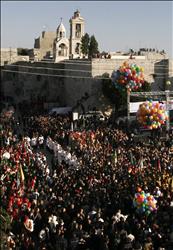 فلسطينيون يتجمعون أمام كنيسة المهد التي شهدت ميلاد السيد المسيح، خلال الاحتفالات بعيد الميلاد في بيت لحم أمس.