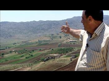 مشهد من الوثائقي يشير فيه سوري من «مزرعة دير العشاير» الى تداخل الاراضي السورية - اللبنانية